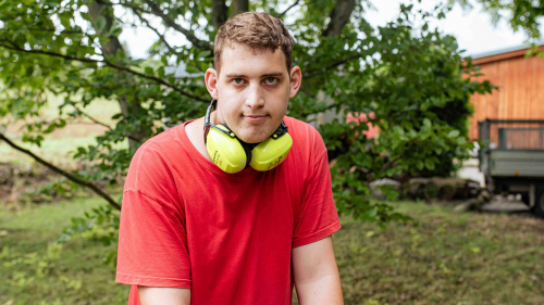 Auszubildender mit Ohrschutz beim Gartenbau.