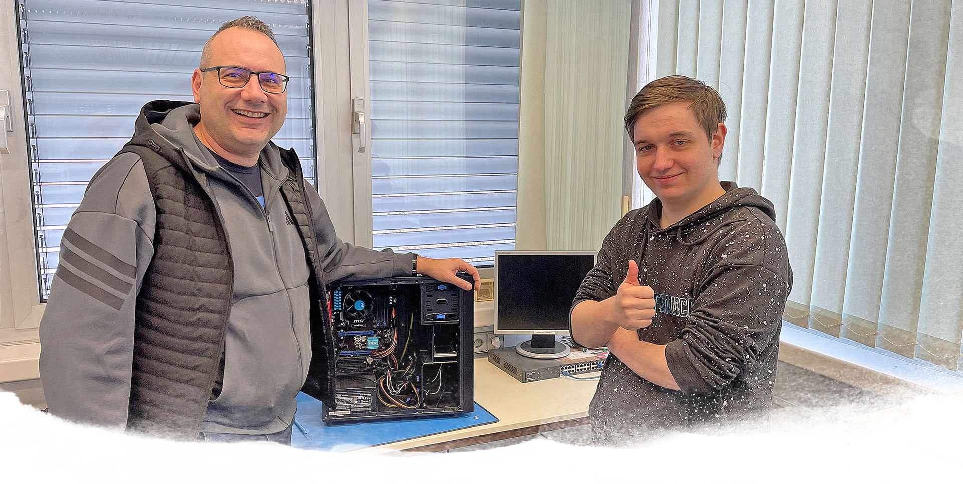 Computer-Reparaturwerkstatt in Winnenden IT-Asubilder und IT-Azubi stehen vor offenem Desktop-PC