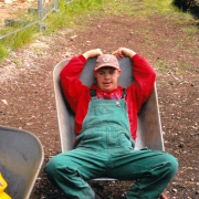 Ein junger Mann liegt in einer Schubkarre.