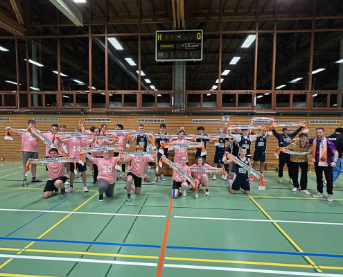 Gruppenbild mit allen Basketball-Spieler*innen mitten der Sporthalle.