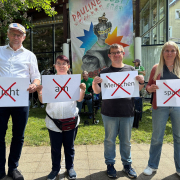 Vier Menschen mit Plakaten in der Hand: Nicht am Menschen sparen. Jedes Wort ist mit einem roten Kreuz durchgestrichen.