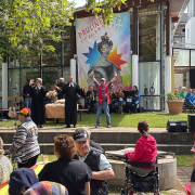 Zwei Pfarrer und ein junger Mann stehen auf der Festival-Bühne.