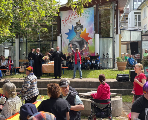 Zwei Pfarrer und ein junger Mann stehen auf der Festival-Bühne.